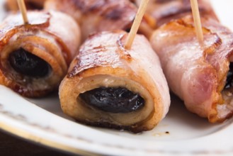 Baked prunes in bacon on a plate, lodz, poland