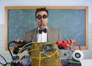 Nerd electronics technician retro teacher silly expression with big battery clamps in pcb