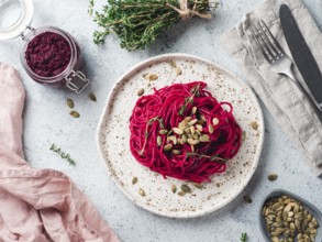 Beetroot pesto or hummus. Homemade beet pesto sauce in glass jar and fresh thyme on dark black