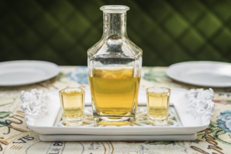 Carafe with honey vodka on white elegant tray