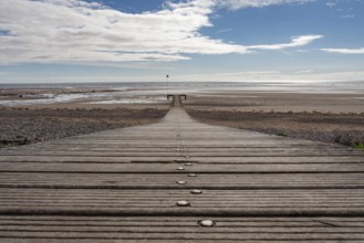 The beach and a wooden walkway in Seascale, Cumbria, England, UK