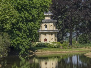 Historic turret flanked by trees, reflected in the neighbouring water, ulft, gelderland,