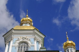 Baroque building with a blue façade and magnificent golden domes against a deep blue sky in St.