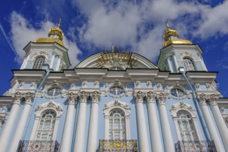 A magnificent church with golden domes, a blue façade and white columns