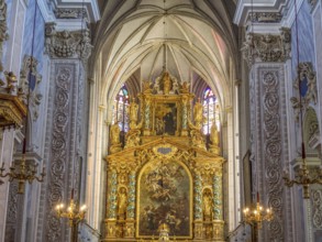 Gold-decorated altar in the Baroque church interior with ornate paintings and decorative details on