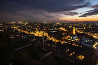 Sunset over the old town of Graz, view from the Schlossberg, illuminated tower of the Franciscan