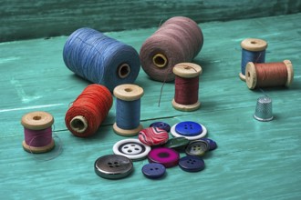 Thread buttons for crafts on turquoise wooden background.selective focus