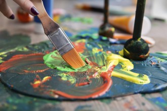 A vibrant and lively scene of paint mixing vividly on a canvas, showcasing colorful strokes and