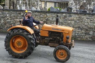 Old tractor Someca in front of church and chapel Sainte Nonne, vintage car meeting Dirinon,