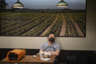 06.03.2020, Singapore, Republic of Singapore, Asia, A man sleeps in a Starbucks cafe and wears a