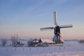 Wingerdse mill near Oud-Alblas in the Dutch region Alblasserwaard in a misty and wintry landscape