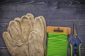 Set of garden shears tie wire safety gloves on vintage wood board gardening concept