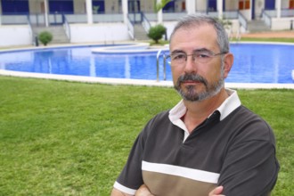 Senior retired man glasses relax on vacation garden pool