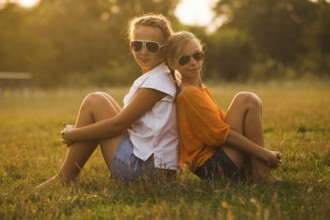Two teenage girls have fun in the park. Two friends outdoor. Summwer people in glasses