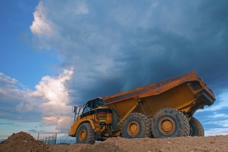 Yellow mining truck at work site before heavy storm