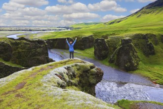Fantastic country Iceland. Enthusiastic woman - tourist on a rock canyon Fjadrargljufur