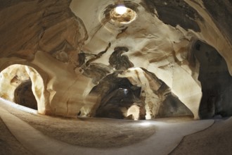 Israel National Park. Bell caves of Beit Guvrin. Picturesque clay arches illuminated by the sun