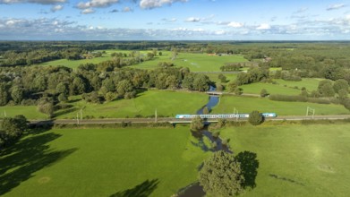 Aerial view of a train in a beautiful green landscape in eastern netherlands