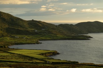 Coastal landscape on the Ring of Kerry near Waterville, with green fields and scattered houses in