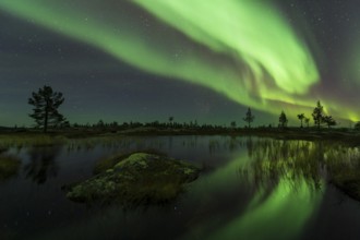Northern Lights (Aurora borealis) reflected in a mountain lake, Gällivare, Norrbotten, Lapland,