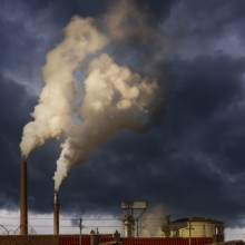 Dark smoke comming from the chimneys of an old factory