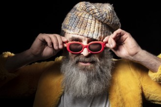 Fashionable older bearded man in light coloured clothes on a black background