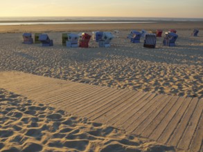 Empty beach chairs scattered on the sandy beach at sunset, langeoog, germany