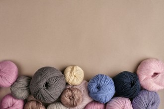 Set of colorful wool yarn on beige background. Knitting as a kind of needlework. Colorful balls of