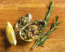 Salad in oyster served with greens and lemon on a wooden background