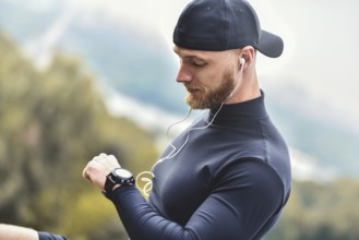 Close-up Shot Bearded Sportive Man After Workout Session Checks Fitness Results. Adult Guy Wearing