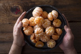 Presentation of Small peeled mandarin oranges on old wooden table