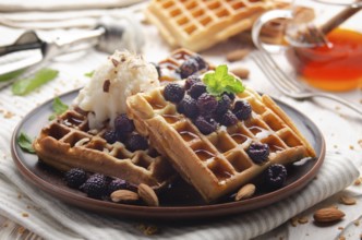 Homemade crispy Belgian waffles served with blackberries honey and icecream