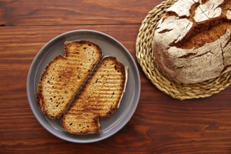 Rye bread toasted slices on dark wooden table top view