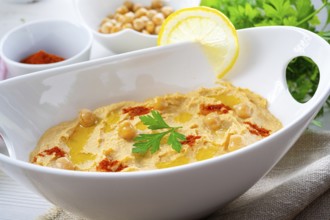 Hummus paste with lemon and chilli on a white background
