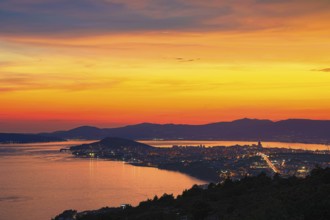 View of a city at dusk with vivid colours in the sky and reflecting water, Split, Dalmatia,