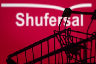 A silhouette of a shopping cart is in front of shufersal. Super-sal, is the largest supermarket
