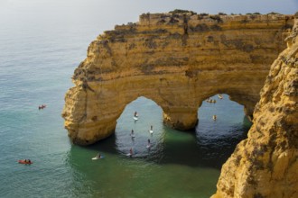 Lagoa, Portugal, September 2022: Kayaks and sup boards peddling under the Arco Natural on the