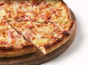 Close up view on piece of pizza with ham and pineapple on wooden cutting board. Isolated on white