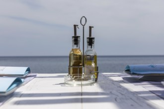 Bottle with vinegar and oil on a restaurant table, Perissa, Santorini Island, Cyclades, Greece,