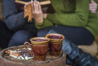 Two cups of coffee are on wooden barrel