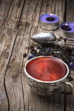 Still life with old cups of brewed herbal tea and scattered welding