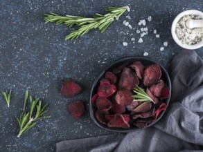 Baked beet slices with coarse sea salt scented rosemary. Vegan diet food idea and recipe. Healthy