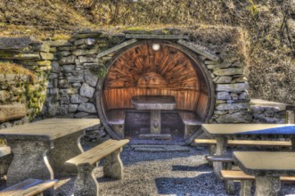 Rustic Restaurant with Tables and Benches Made in Stone and Wood in Circle Shape in a Sunny Day in
