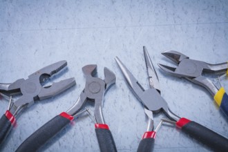 Composition of insulated metal nippers on scratched metallic background