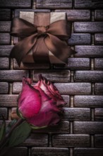 Red scented rose present box on wicker wooden place mat