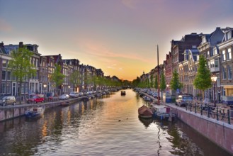 Buildings and boats along the canal at sunset time in Amsterdam, Netherlands