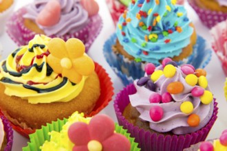 Many sweet birthday cupcakes with flowers and butter cream