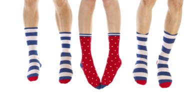 Feet in striped and dotted socks isolated over white background