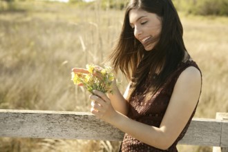 Beautiful woman in golden outdoor with yellow flower