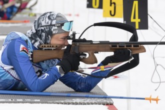 Sportswoman biathlete Arina Soldatova Kamchatka Krai rifle shooting prone position. Biathlete in